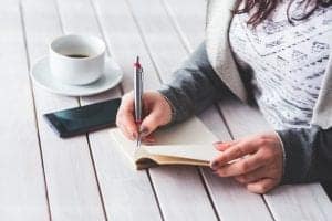 woman writing in notepad