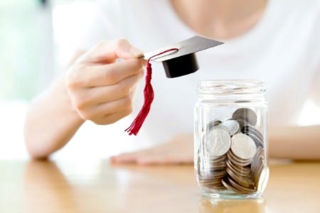 Jar of coins with graduation cap