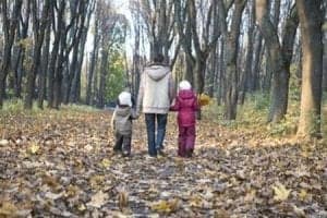 mum and two children walking through woods