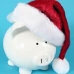 White piggy bank wearing red Santa hat