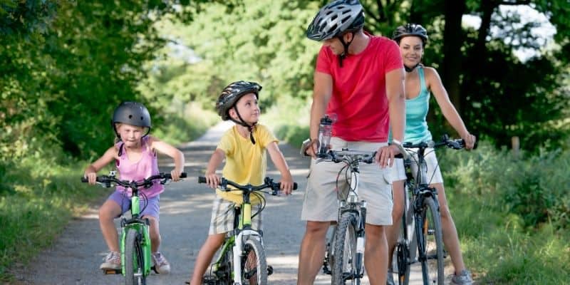 family cycling along road