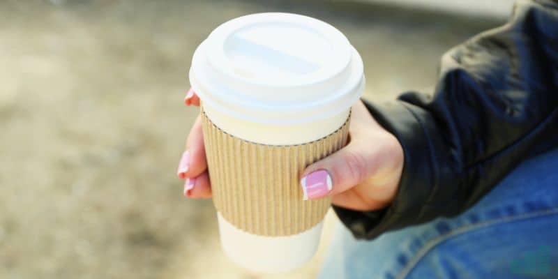 Hand holding takeaway coffee
