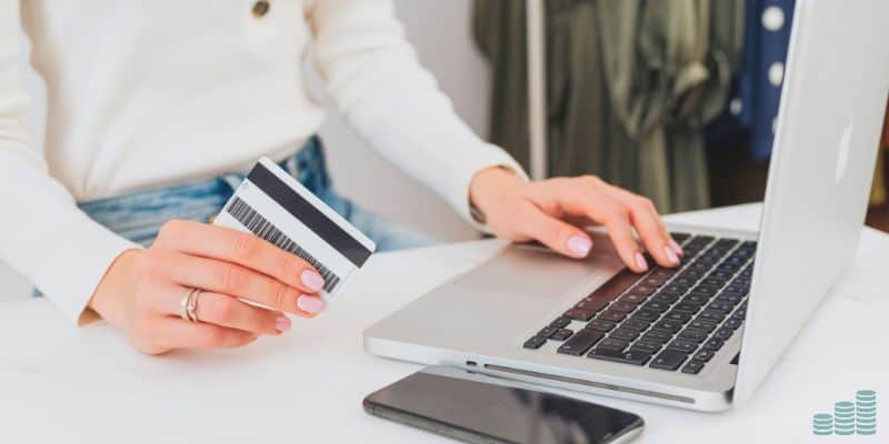 woman holiding credit card making purchase on laptop.