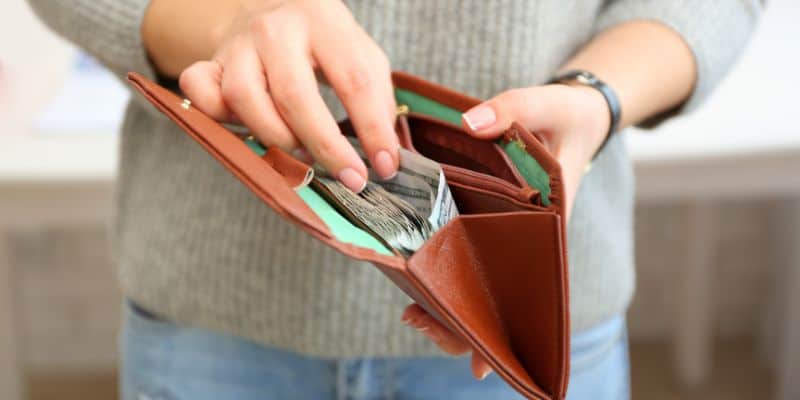 hands holding wallet with money in