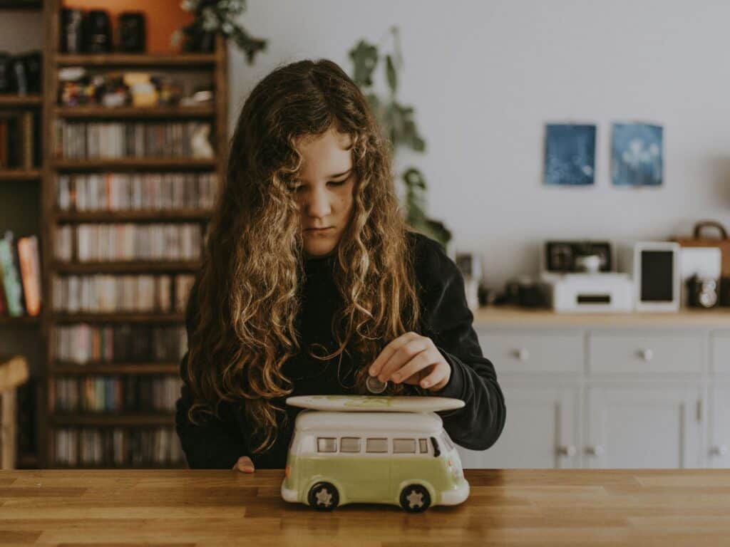 Girl putting coin into moneybox